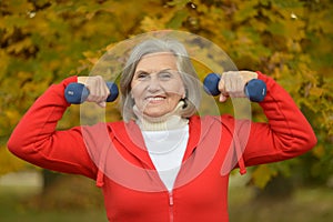 Fit Senior woman exercising with dumbbells