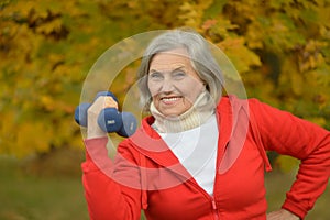 Fit Senior woman exercising with dumbbells