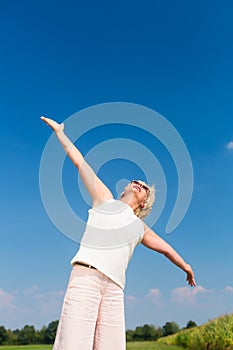 Fit senior woman looking up to the sky while enjoying retirement