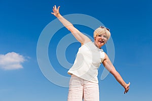 Fit senior woman looking up to the sky while enjoying retirement