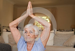 Fit senior woman practising yoga alone at home photo