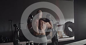 Fit shirtless sportsman doing lunges with dumbbells