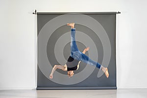 Fit skilled man performing acrobatic trick in studio