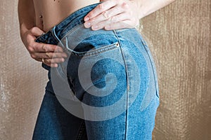 Fit slim female in blue jeans. Woman buttocks in denim.