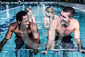 Fit smiling group pedaling on swimming bike