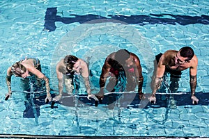 Fit smiling group pedaling on swimming bike