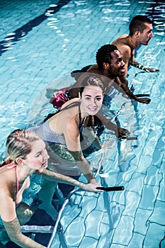 Fit smiling group pedaling on swimming bike photo