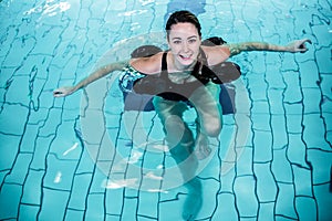 Fit smiling woman doing aqua aerobics