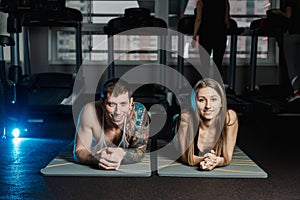 Fit sportive man and woman doing plank core exercise training back and press muscles concept gym sport sportsman fitness