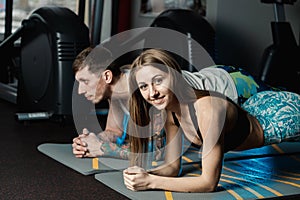 Fit sportive man and woman doing plank core exercise training back and press muscles concept gym sport sportsman fitness