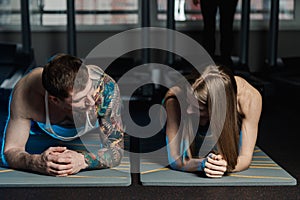 Fit sportive man and woman doing plank core exercise training back and press muscles concept gym sport sportsman fitness