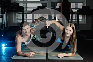 Fit sportive man and woman doing plank core exercise training back and press muscles concept gym sport sportsman fitness