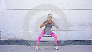 Fit sportswoman squatting with resistance band