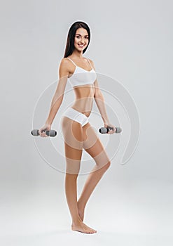 Fit and sporty girl in white swimsuit. Sport, fitness, diet, weight loss and healthcare concept.