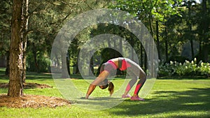 Fit sporty woman doing backbend exercise outdoors