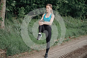 Fit sporty woman in sportswear stretching legs