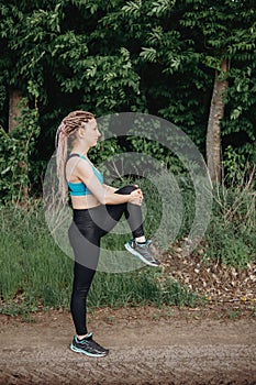 Fit sporty woman in sportswear stretching legs