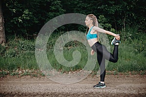 Fit sporty woman in sportswear stretching legs