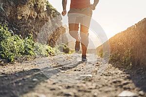 Fit tattoo man doing jogging session alone during Coronavirus quarantine  - Workout and fitness lifestyle concept - Focus on feet