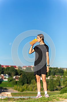 Fit tennage girl runner outdoors holding water bottle