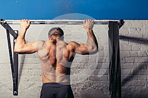 Fit toes to bar man pull-ups bars workout exercise at gym