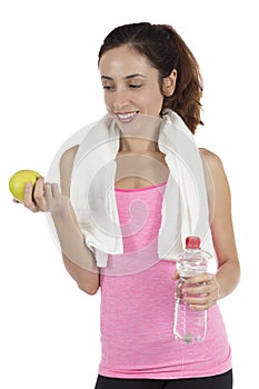 Fit woman with an apple and a bottle of water with a towel around her neck