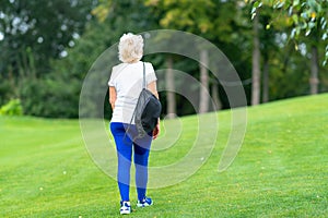 Fit woman carrying a sports bag walking away