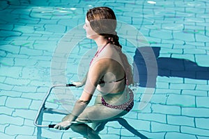 Fit woman cycling in the pool