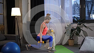 Fit woman with dog doing lunge excercise at home