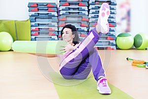 Fit woman doing abs workout exercise russian twists with raised leg