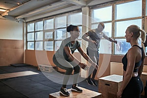 Fit woman doing box jumps during a gym workout