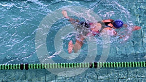 Fit woman doing the breast stroke in swimming pool