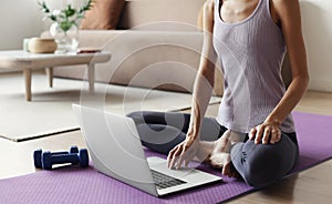 Fit woman doing fitness exercises at home. Online video training. Girl doing exercises and meditate.