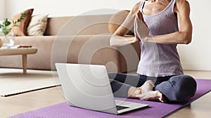 Fit woman doing fitness exercises at home, online video training. Girl doing exercises and meditate.