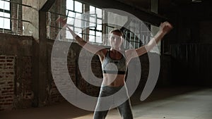 Fit woman doing jumping jack exercise at fitness gym