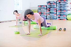 Fit woman doing pilates exercises stretching arching her back at fitness studio