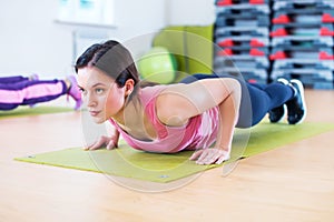 Fit woman doing plank exercise and push ups working on abdominal muscles triceps.
