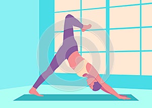 Fit woman doing yoga downward facing dog split pose