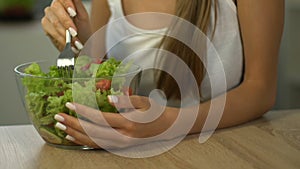 Fit woman eating salad instead of cake, choice of healthy lifestyle, close up