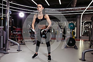 Fit woman execute exercise with exercise-machine Cable Crossover in gym
