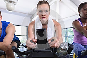 Fit woman exercising on exercise bike in fitness center