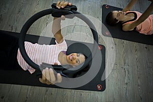 Fit woman exercising with pilates ring