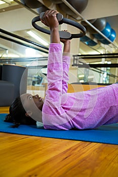 Fit woman exercising with pilates ring on mat