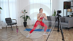 Fit woman fitness trainer blogger doing warm-up exercise workout at modern home