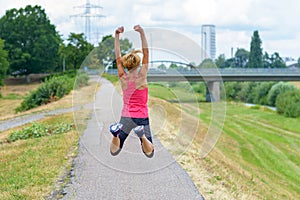 Fit woman full of vitality leaping in the air