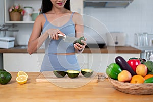 A fit woman in gym clothes preparing her healthy breakfast in the kitchen before going to the gym