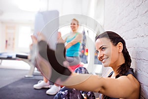 Fit woman in gym holding smart phone, taking selfie