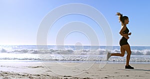 Fit woman jogging in the beach 4k