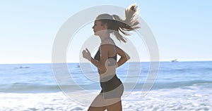 Fit woman jogging in the beach 4k