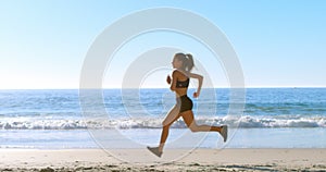 Fit woman jogging in the beach 4k